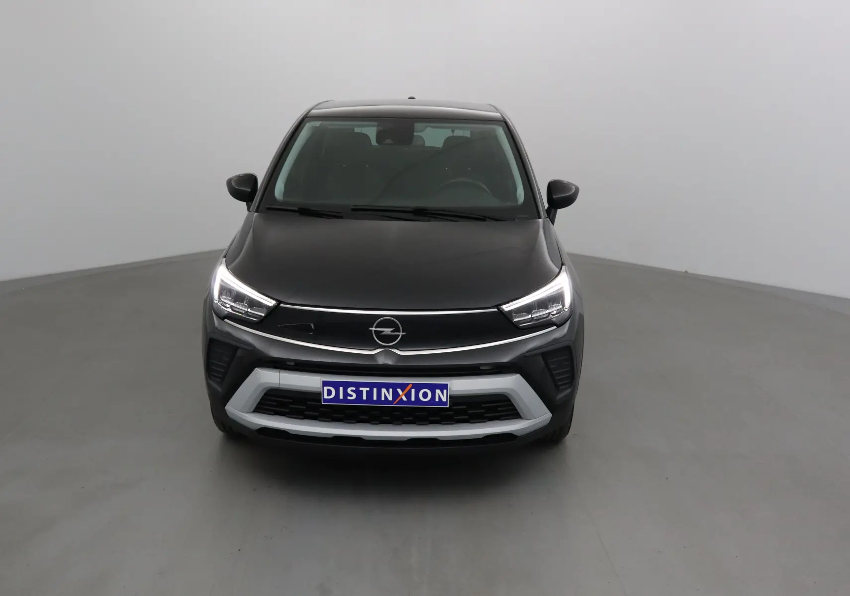 Vue frontale d'un Opel Crossland noir 2022 avec feux LED allumés et calandre argentée distinctive.