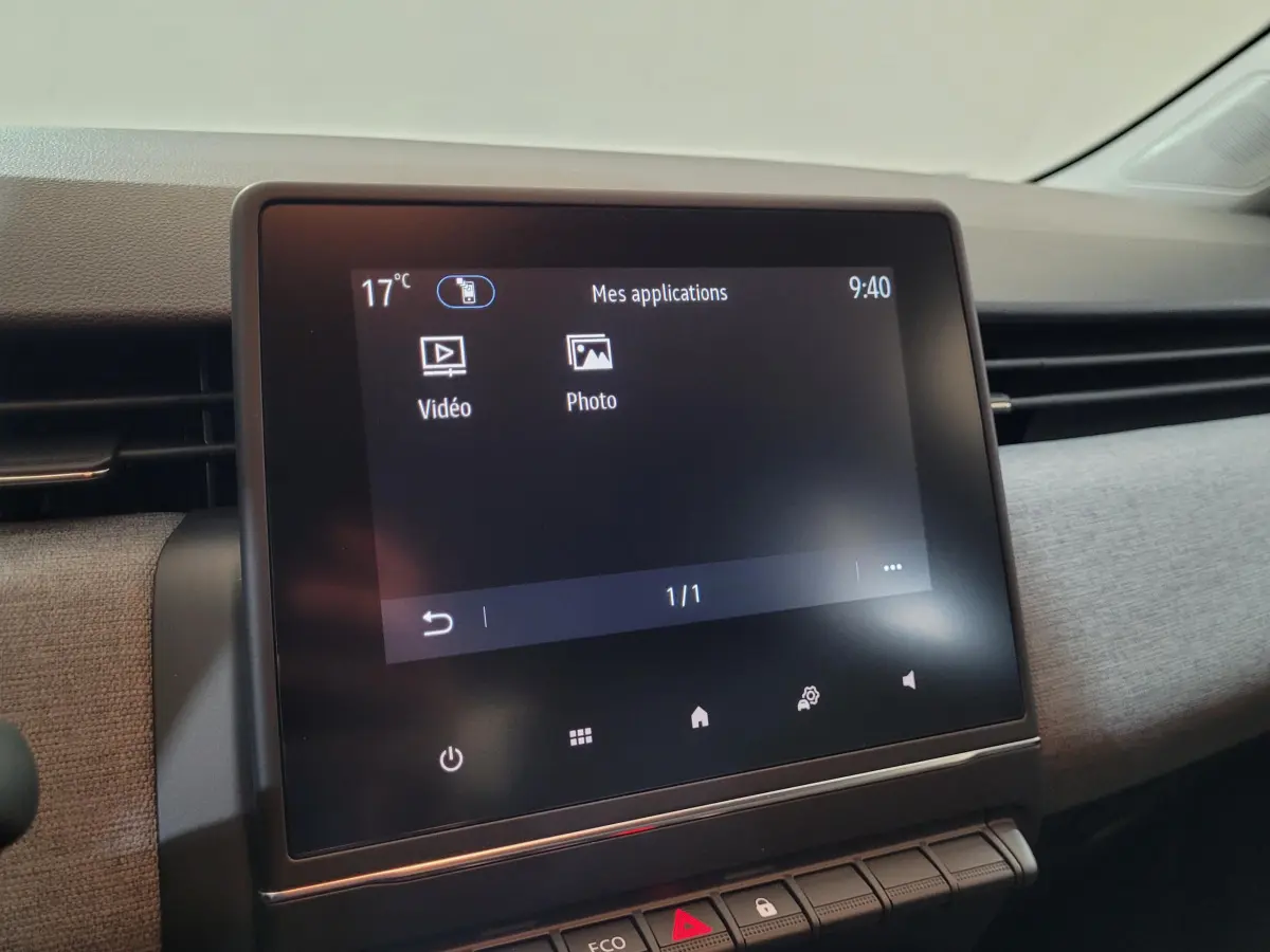 Écran tactile central affichant les applications vidéo et photo dans l'habitacle moderne de la Renault Clio bleu.