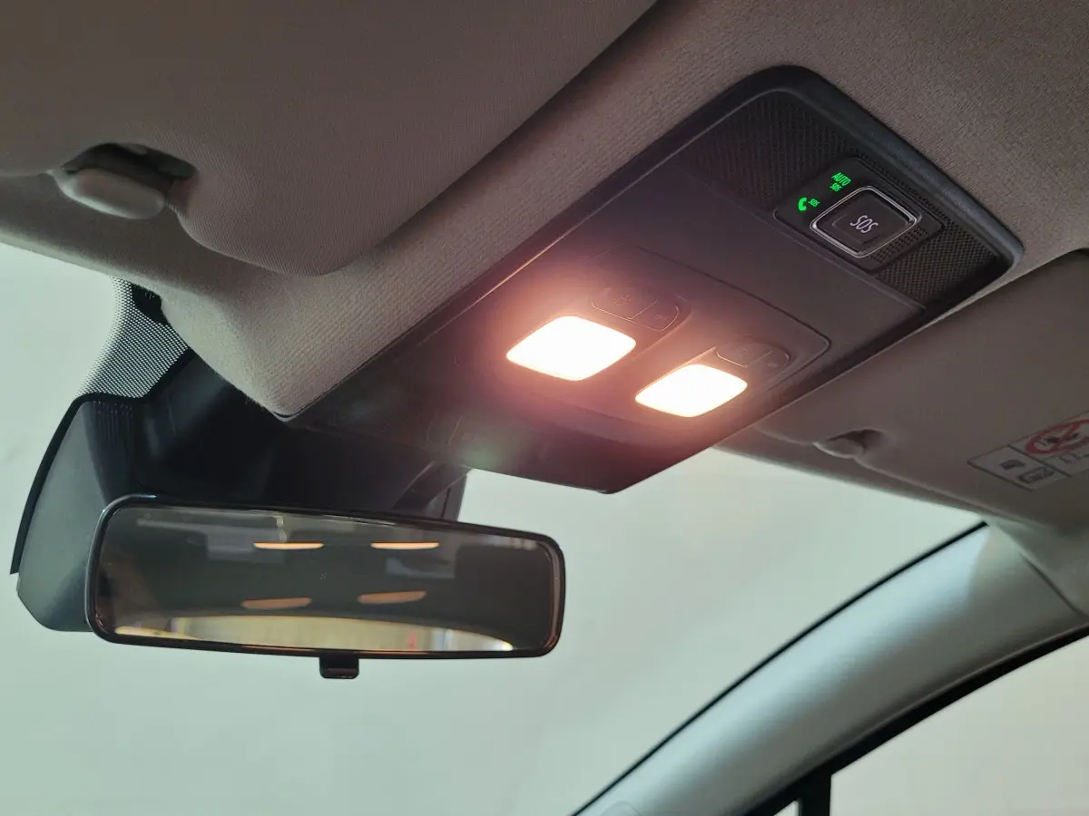 Plafonnier intérieur allumé avec bouton SOS et rétroviseur central dans une Renault Clio bleu 2025.