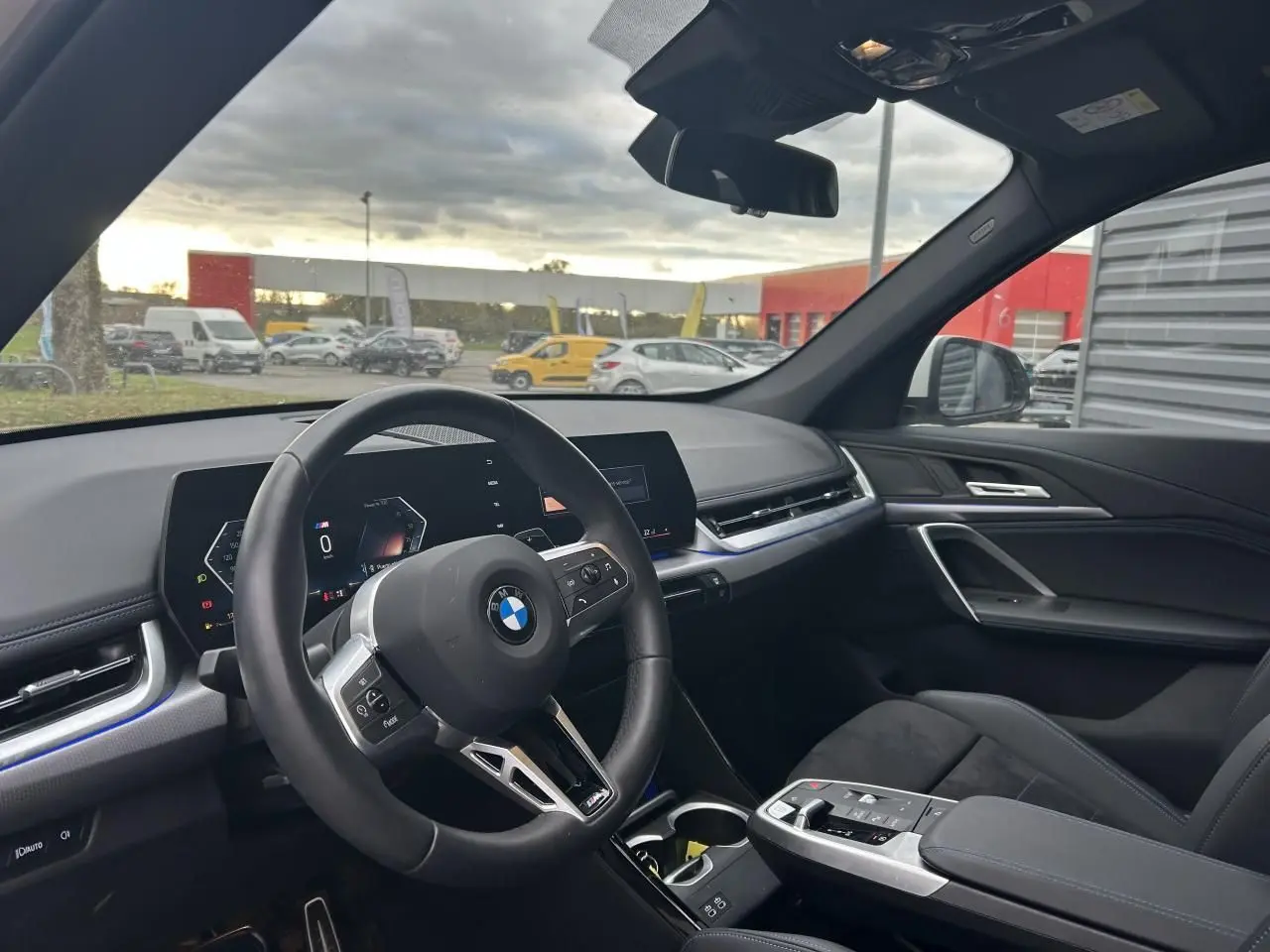 Vue intérieure côté conducteur du BMW X1 2025 Black Saphire, tableau de bord moderne et volant multifonction M Sport.