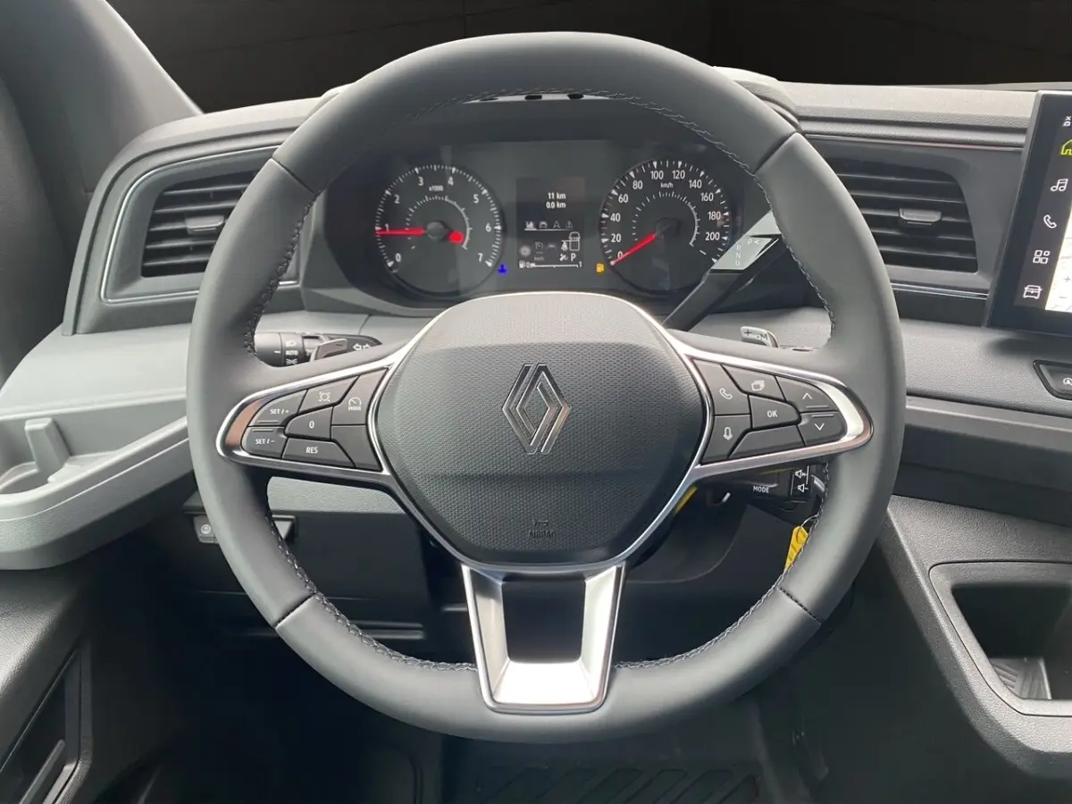 Vue rapprochée du volant noir du Renault Master 2026 avec tableau de bord numérique et commandes intégrées.