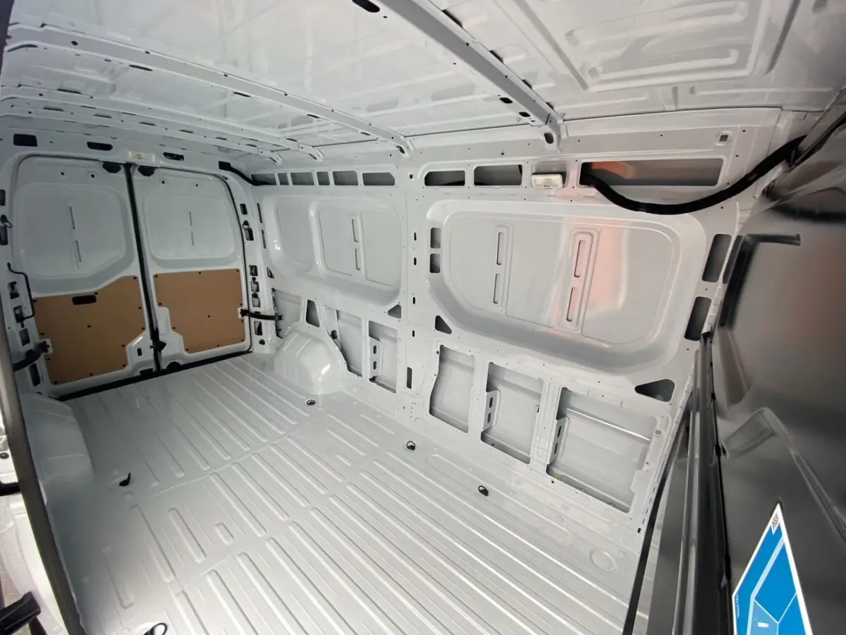 Vue intérieure arrière du Renault Master blanc, montrant l'espace de chargement vide et la cloison pleine.