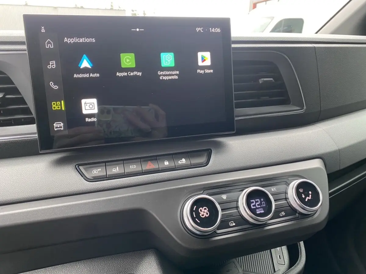 Vue rapprochée du tableau de bord du Renault Master 2026 blanc, avec écran tactile central affichant des applications connectées.