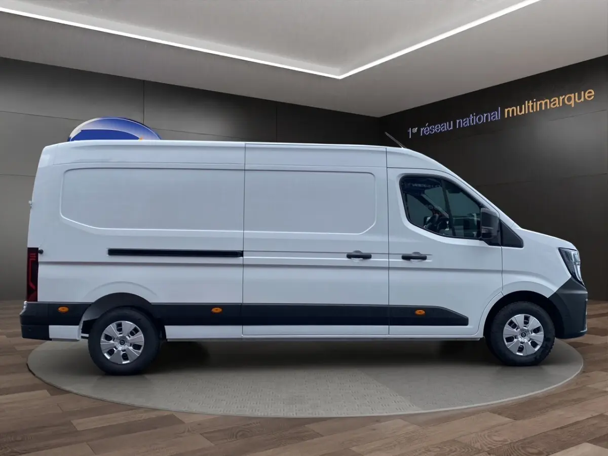 Vue de profil côté droit d’un Renault Master blanc, fourgon utilitaire avec bande noire basse et jantes argentées.