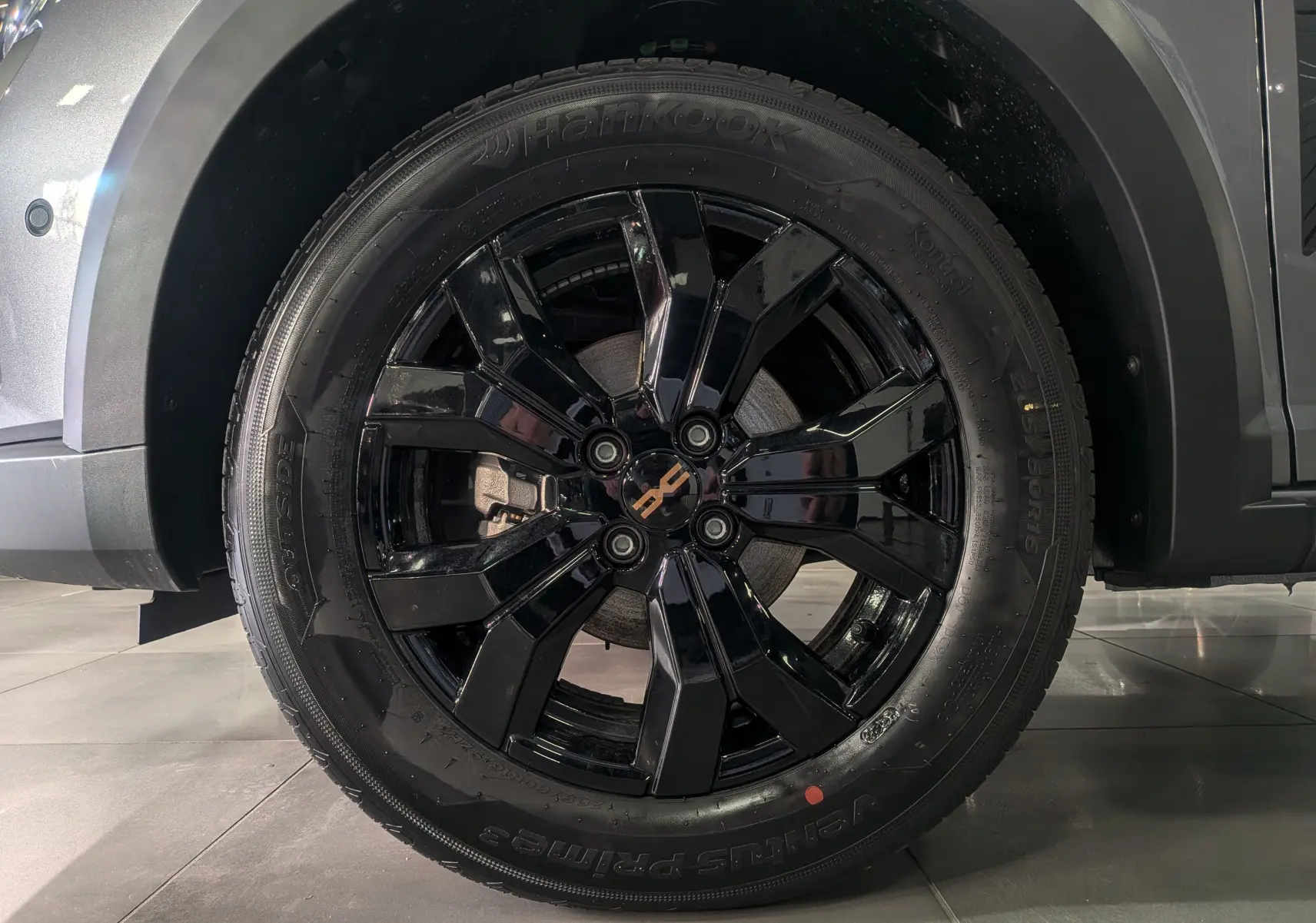 Gros plan sur la roue avant droite noire brillante du Dacia Sandero Stepway Gris Schiste 2025.