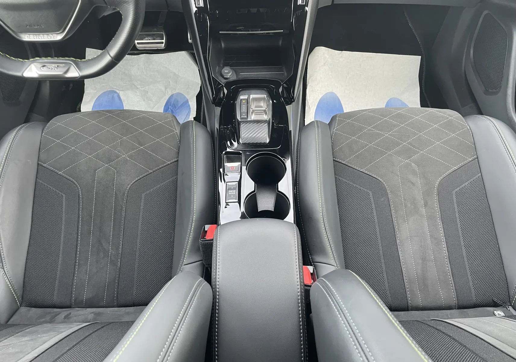 Vue plongeante sur l’intérieur noir du Peugeot 2008 2022, mettant en valeur les sièges sport et la console centrale brillante.