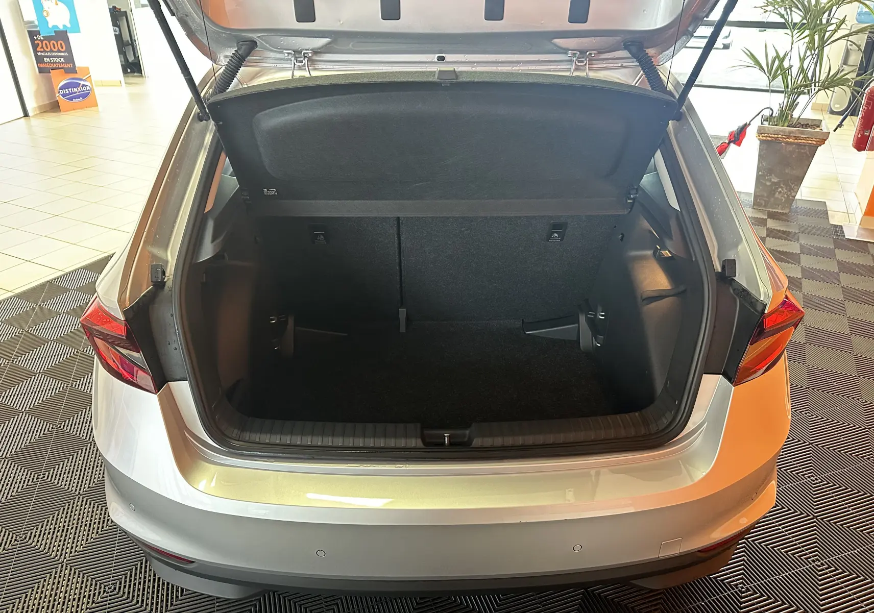 Vue arrière du coffre ouvert d'une Skoda Fabia Ambition gris argent 2023, montrant l'espace de chargement vide.