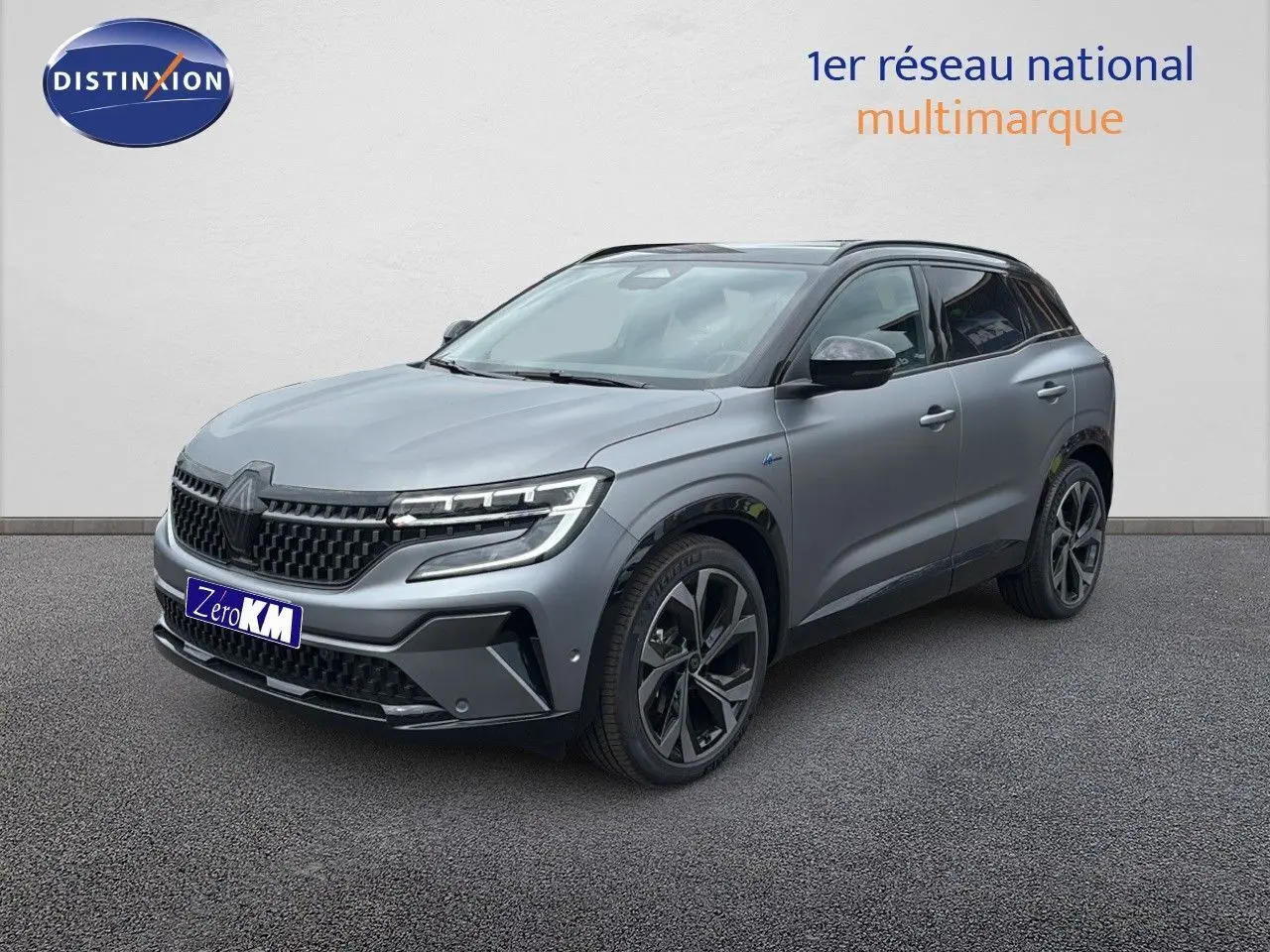 Renault Austral 2024 gris schiste mat en 3/4 avant droit, avec jantes noires et détails Alpine visibles.