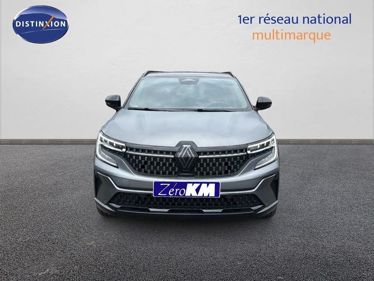 Vue frontale du Renault Austral 2024 gris schiste satin mat avec calandre noire et feux LED distinctifs allumés.