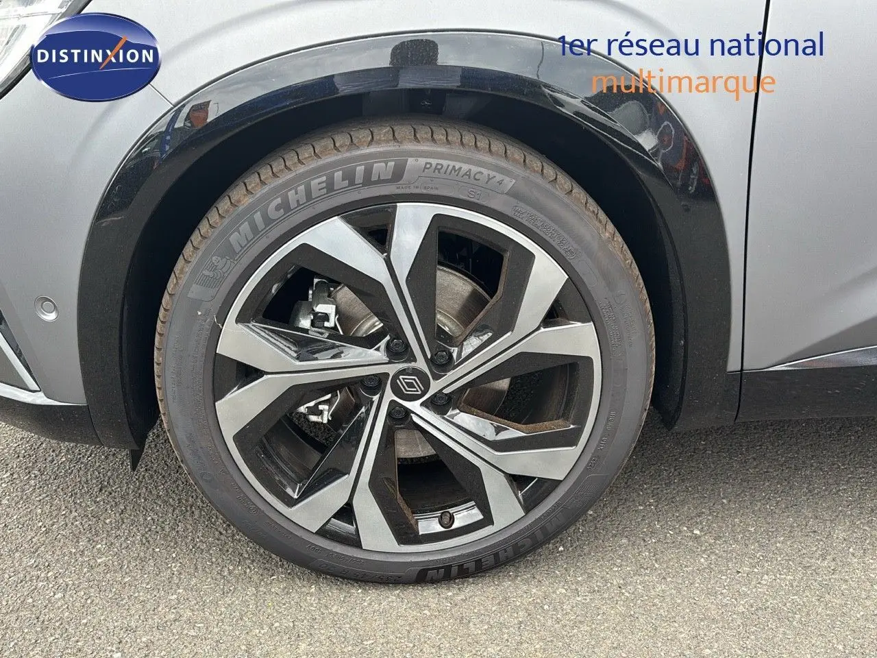 Gros plan sur la roue avant gauche d'un Renault Austral gris schiste satin mat avec jante alliage au design moderne.