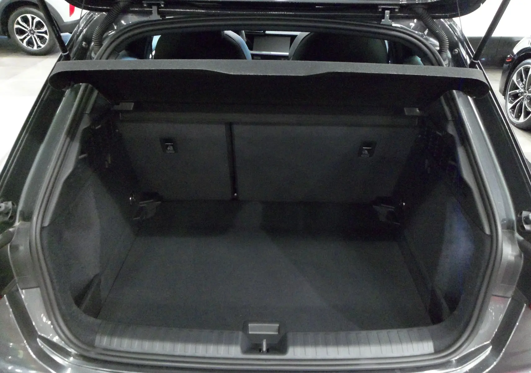 Coffre ouvert de l'Audi A3 Sportback 35 TFSI gris Daytona, montrant l'espace de chargement intérieur vide.