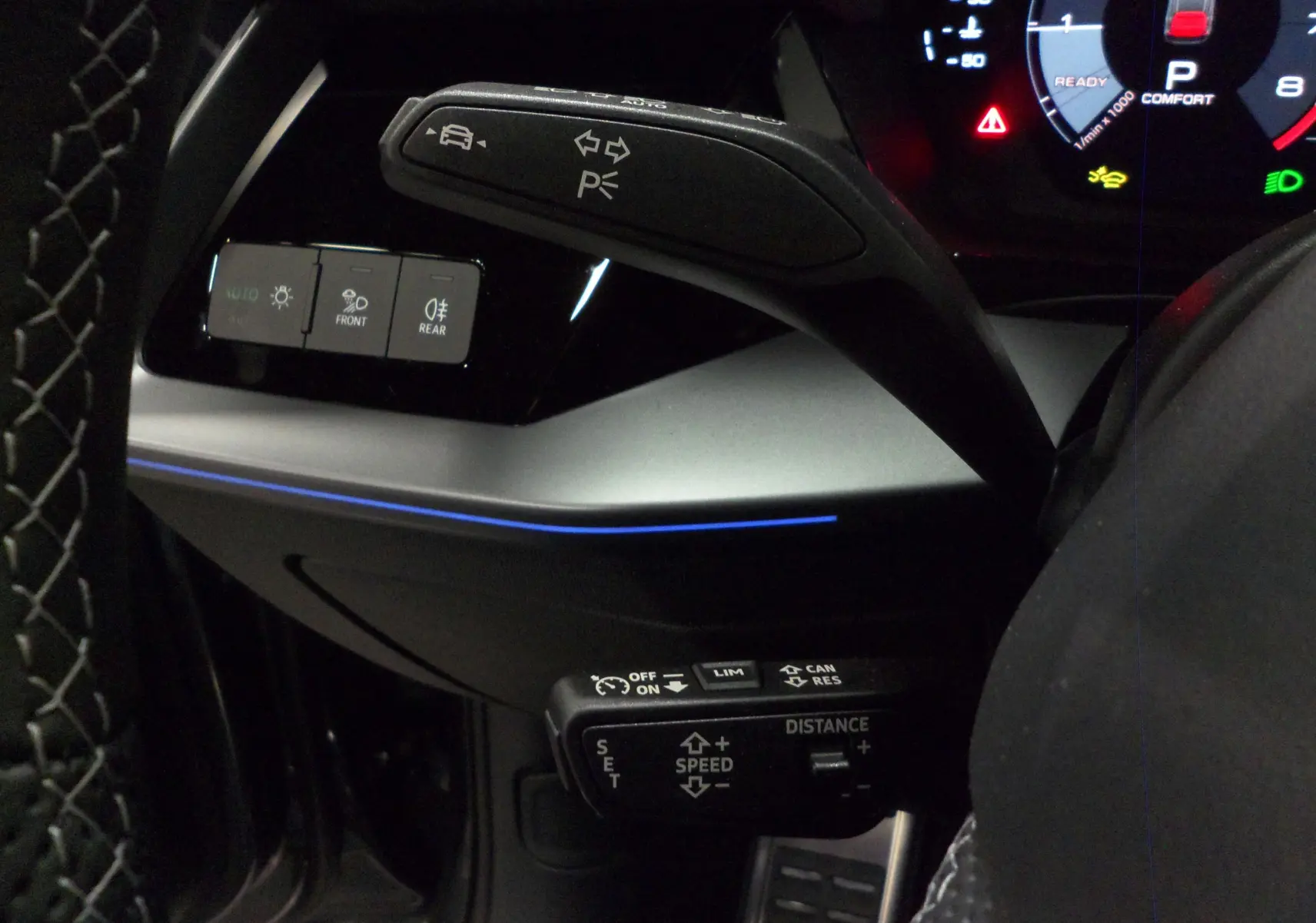 Détail du volant et commandes du régulateur adaptatif sur Audi A3 Sportback 2025 avec éclairage d'ambiance bleu