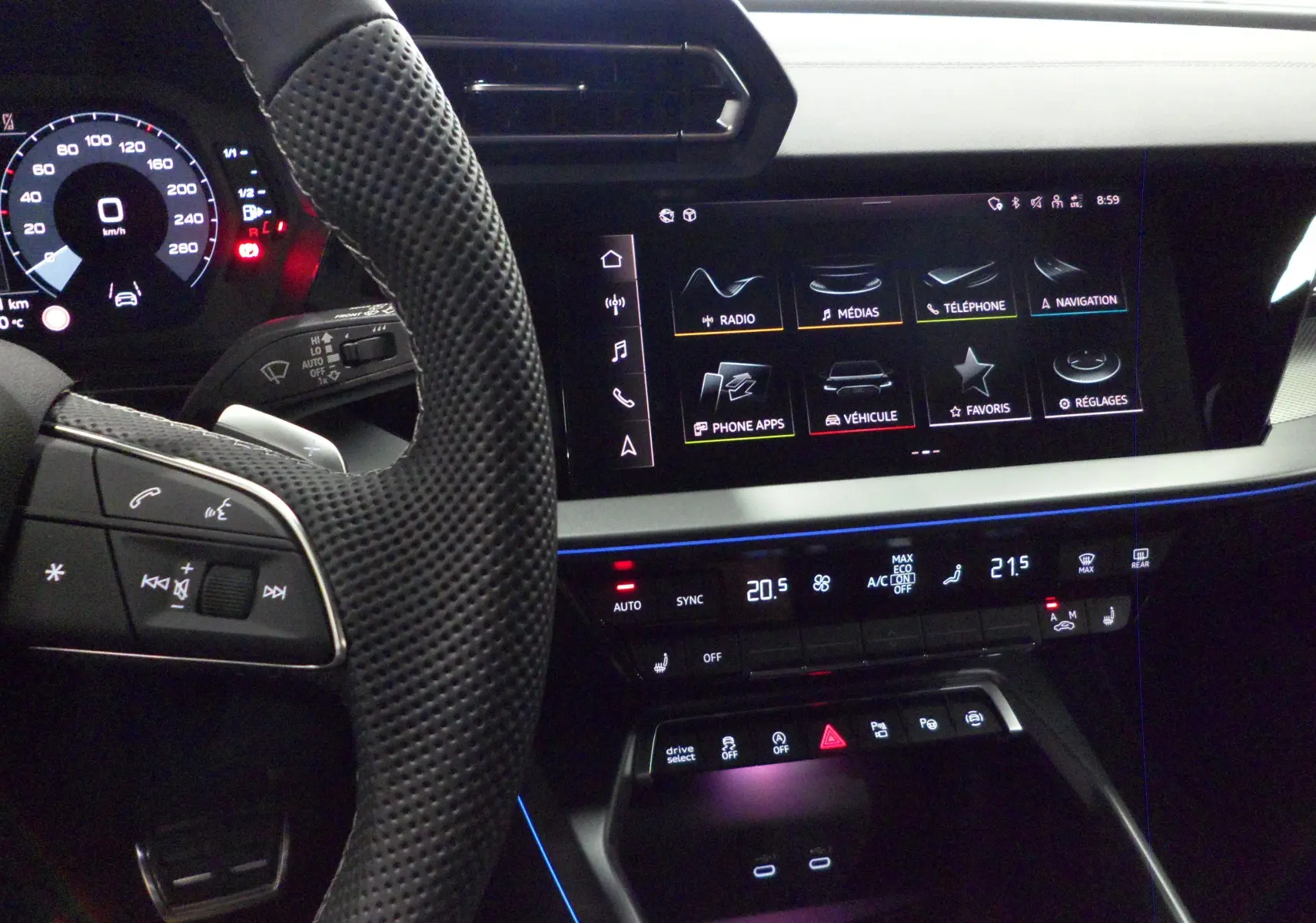 Vue intérieure de l'Audi A3 Sportback 2025, tableau de bord et écran tactile avec ambiance lumineuse bleue.