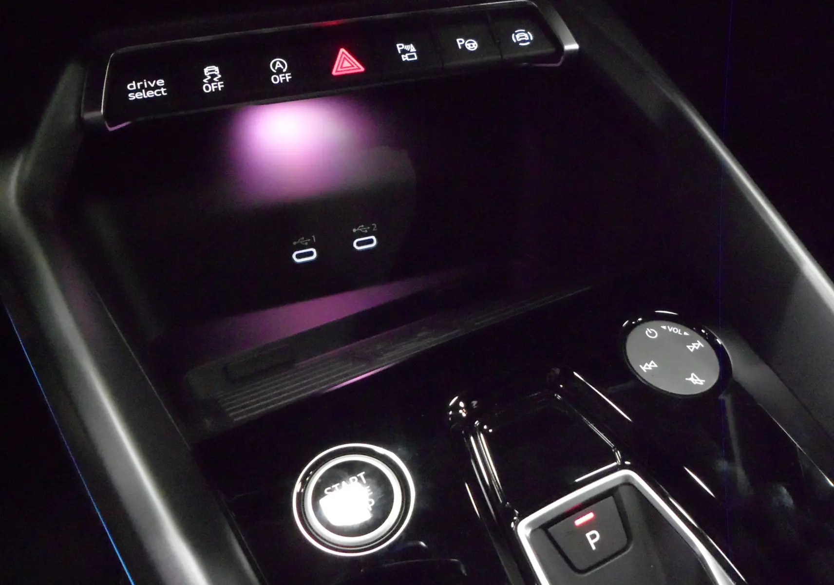 Gros plan sur la console centrale noire de l'Audi A3 Sportback 2025, avec bouton start/stop et commandes tactiles éclairées.