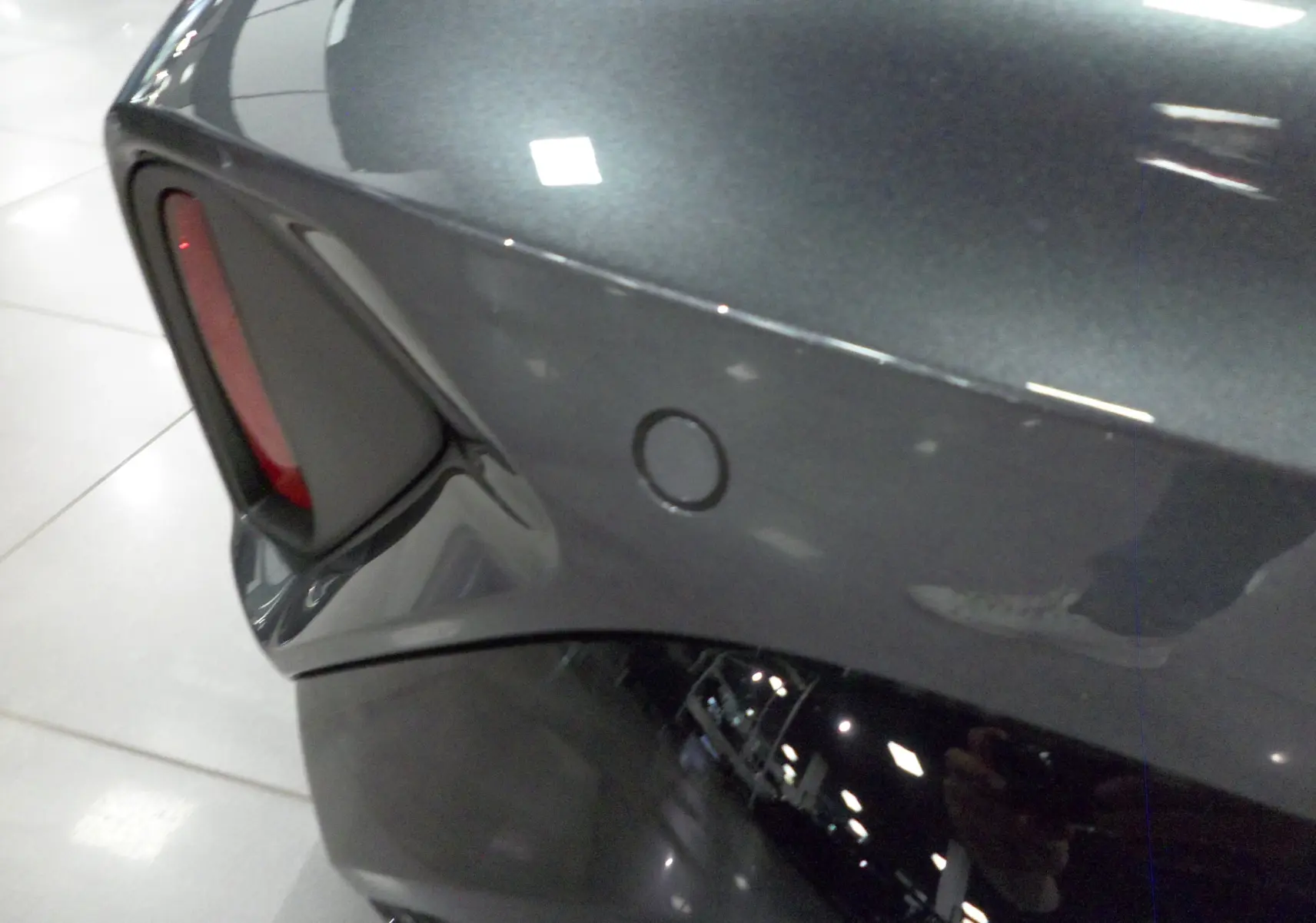 Gros plan sur le feu arrière gauche gris Daytona de l'Audi A3 Sportback 2025 avec capteur de stationnement intégré.