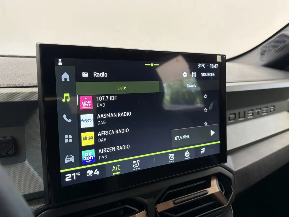 Écran tactile central du tableau de bord du Dacia Duster noir, affichant les stations radio numériques.