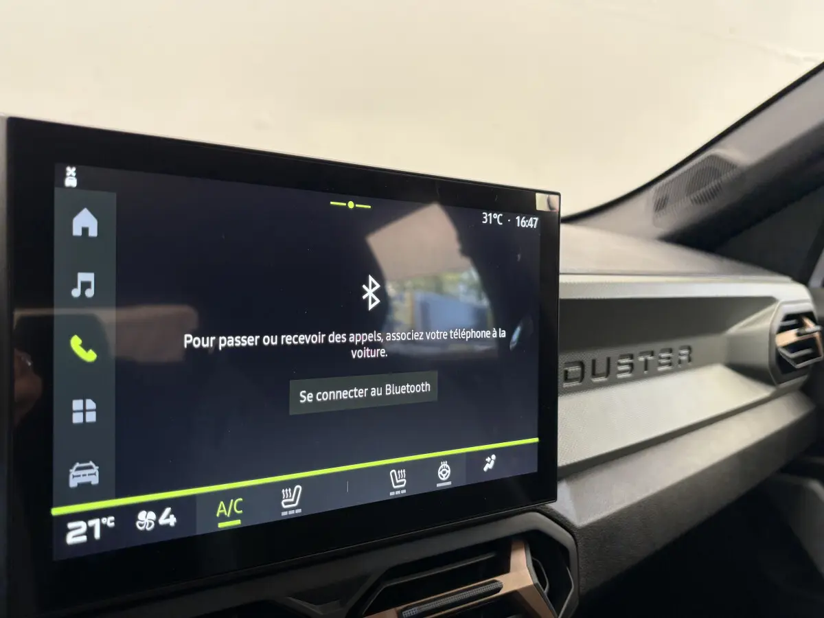 Écran tactile central affichant la connexion Bluetooth dans l'habitacle du Dacia Duster 2025.