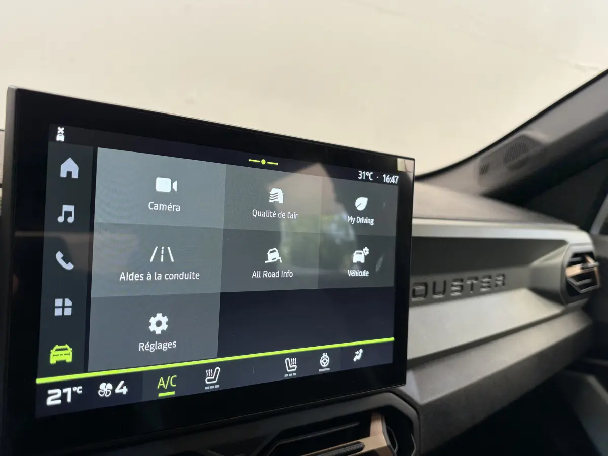 Écran tactile central affichant les options de conduite dans l'habitacle du Dacia Duster noir 2025.