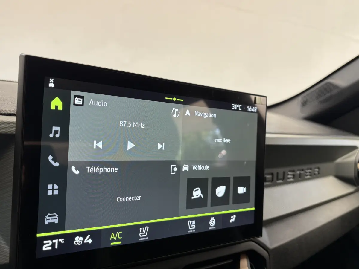 Écran tactile central affichant la navigation et audio dans l'habitacle du Dacia Duster noir 2025.