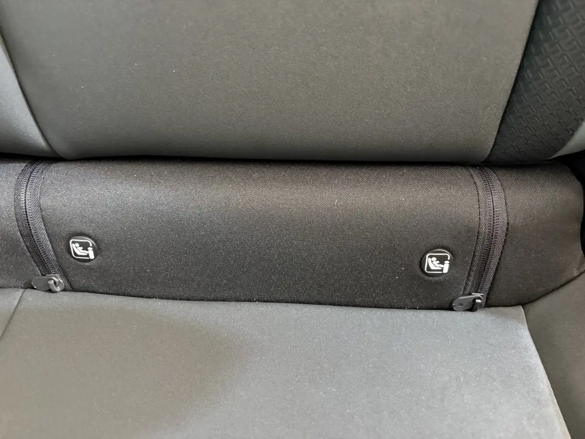 Détail des attaches Isofix sur la banquette arrière noire du Dacia Duster 2025 hybride essence.