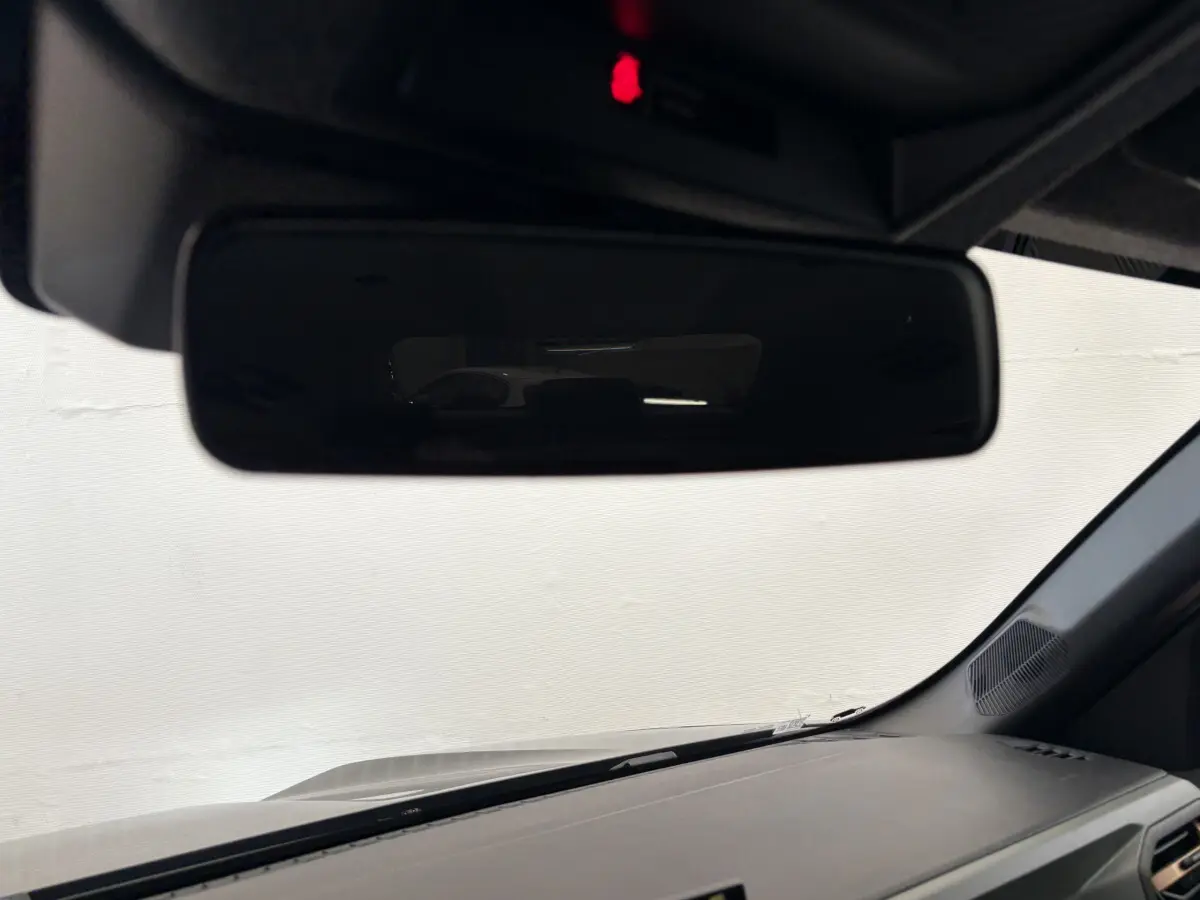 Vue intérieure du rétroviseur central du Dacia Duster noir 2025, avec tableau de bord et pare-brise visibles.