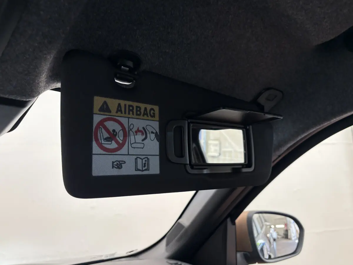 Miroir de courtoisie ouvert sur le pare-soleil côté conducteur du Dacia Duster noir, intérieur vue rapprochée.