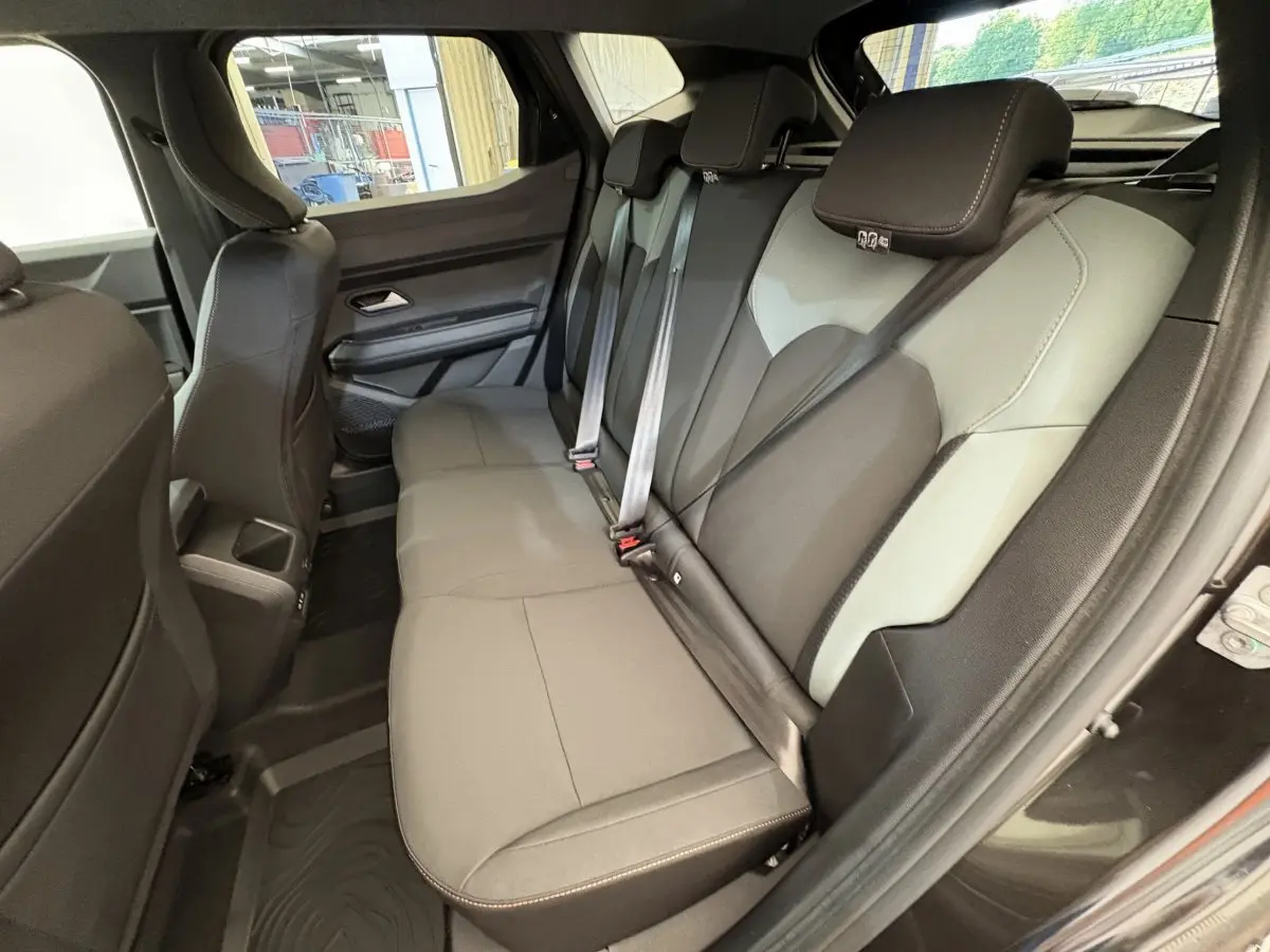 Vue intérieure côté droit sur la banquette arrière bicolore grise et noire du Dacia Duster 2025 noir extreme mild hybrid.