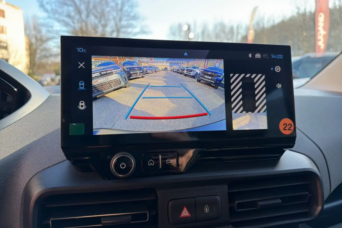Écran tactile intérieur montrant la caméra de recul du Peugeot Rifter blanc kaolin, tableau de bord en arrière-plan.