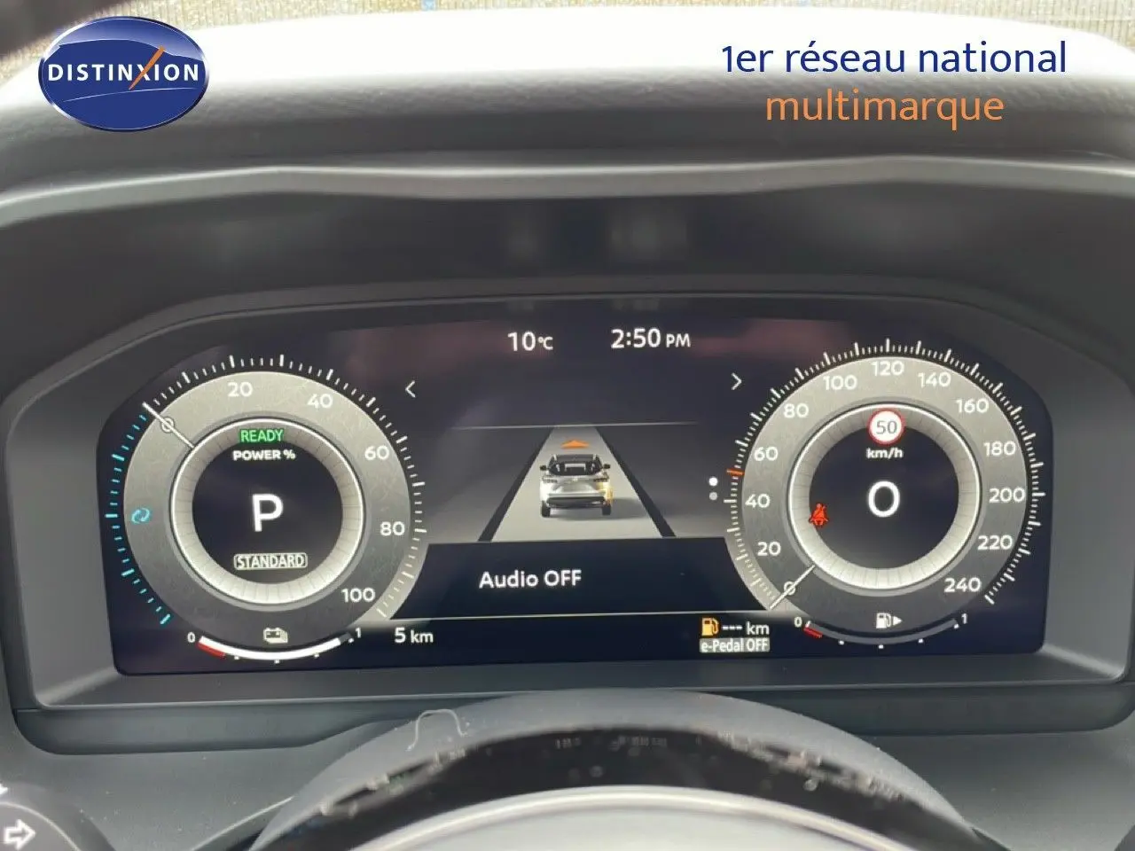 Tableau de bord numérique du Nissan Qashqai gris, affichant vitesse, mode parking et indicateurs de conduite.