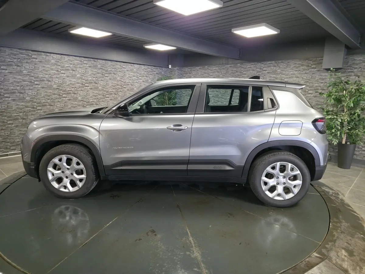 Vue de profil côté gauche du Jeep Avenger gris métallisé 2025 avec jantes alliage 17 pouces et coques de rétroviseurs noires.