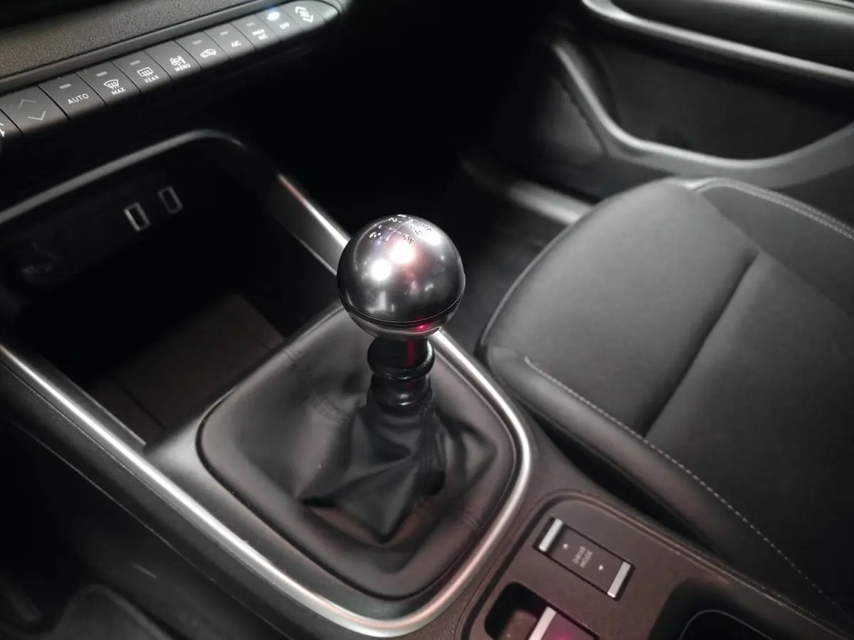 Gros plan sur la boîte manuelle et le siège avant droit noir du Jeep Avenger 2025 gris, intérieur moderne et épuré.