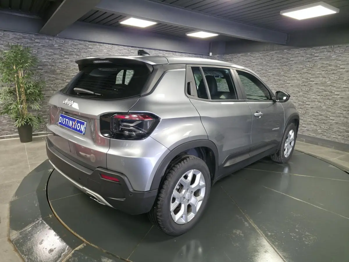 Jeep Avenger gris métallisé en 3/4 arrière droit, avec jantes alliage 17 pouces et feux arrière LED foncés.