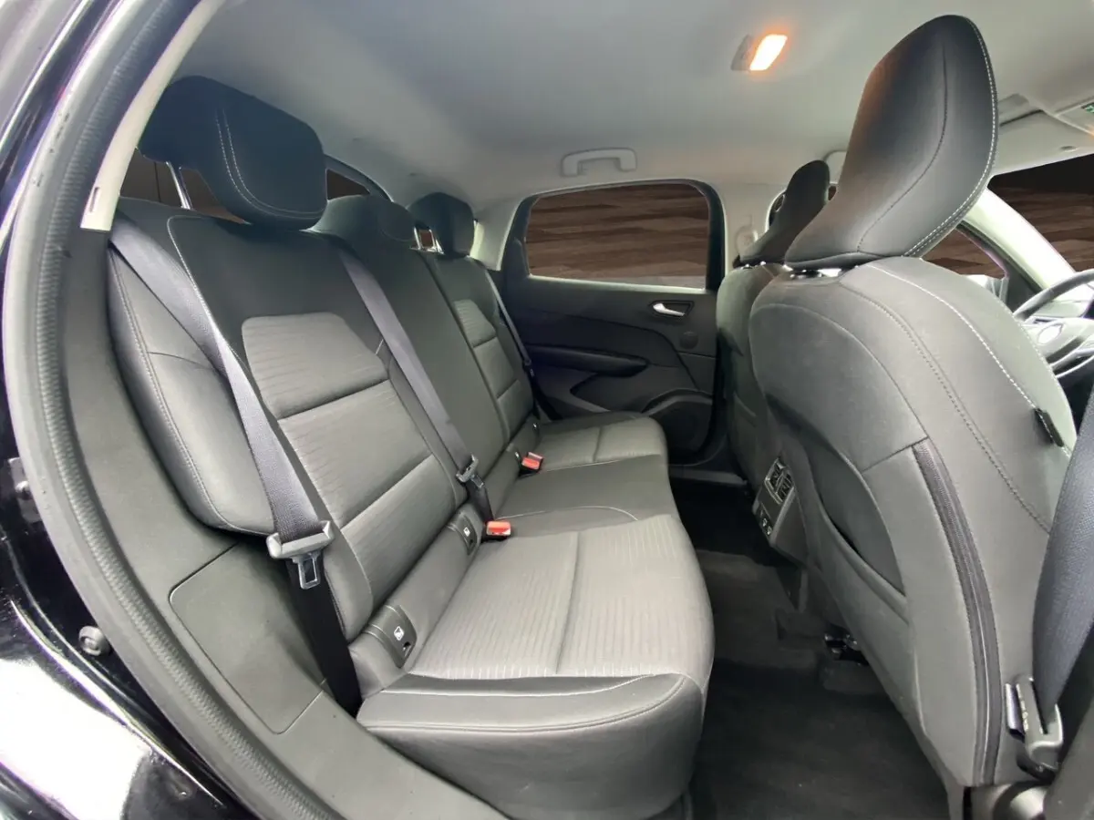 Vue intérieure arrière du Renault Arkana 2024 noir, montrant les sièges arrière en tissu et cuir avec ceinture de sécurité.