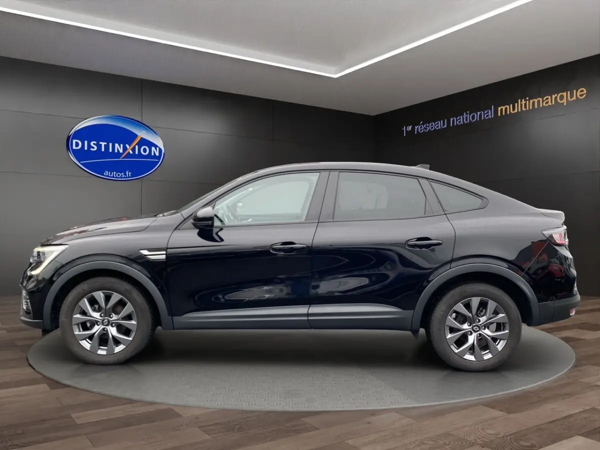 Renault Arkana noir en profil droit, SUV compact avec lignes fluides et jantes alliage visibles en showroom.