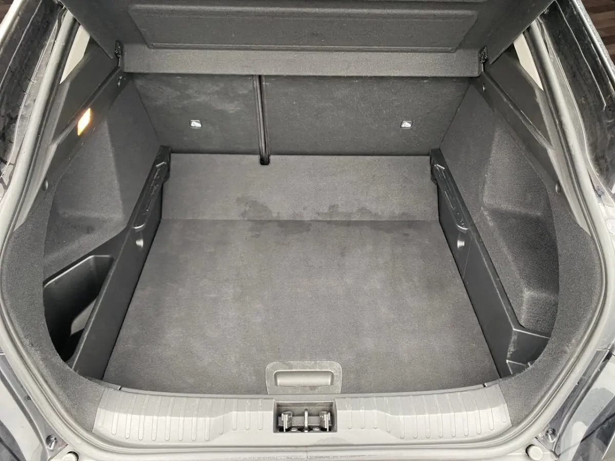 Coffre ouvert du Renault Arkana noir, vue plongeante montrant l'espace de chargement vide et les finitions intérieures.