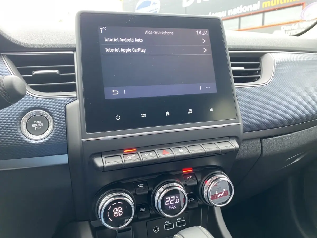 Vue rapprochée du tableau de bord du Renault Arkana 2024, avec écran tactile central et commandes de climatisation digitales.