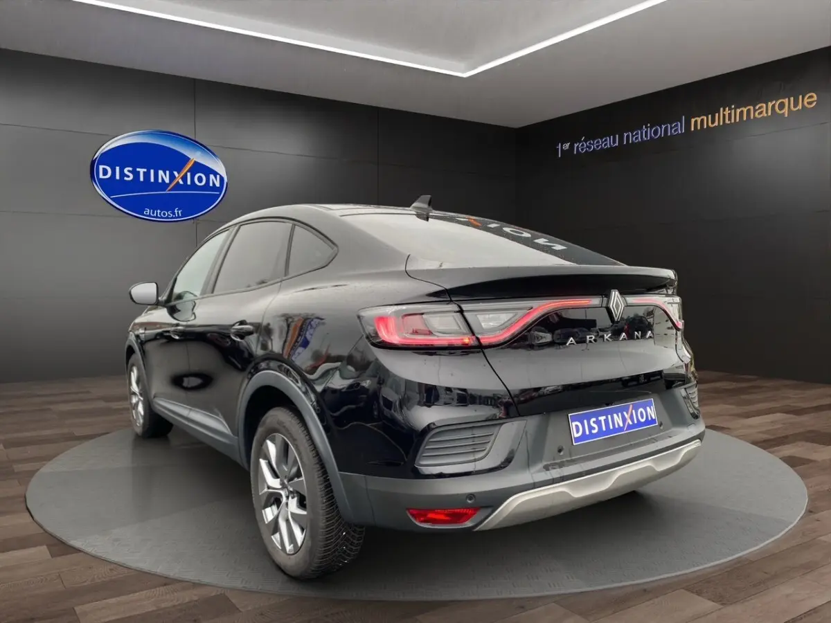 Vue 3/4 arrière droite d'un Renault Arkana noir 2024 avec feux LED et logo ARKANA lumineux sur coffre.