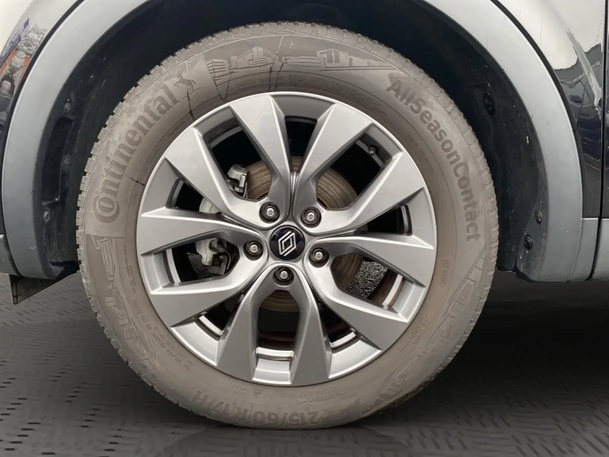 Gros plan sur la roue avant droite du Renault Arkana noir, avec jante alliage et pneu Continental AllSeasonContact.