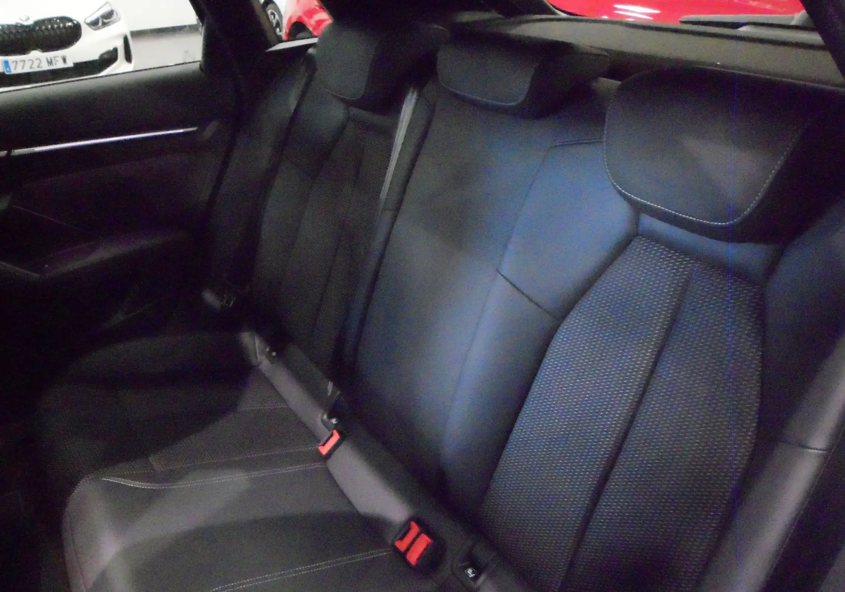 Vue intérieure sur les sièges arrière en cuir noir de l'Audi A3 Sportback 2025, avec ceintures et appuie-têtes visibles.