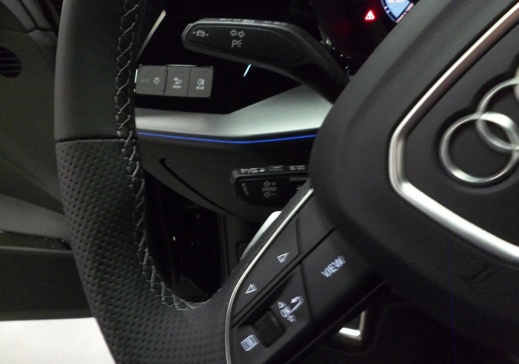 Gros plan sur le volant en cuir noir perforé et les commandes multifonctions d'une Audi A3 Sportback 2025.