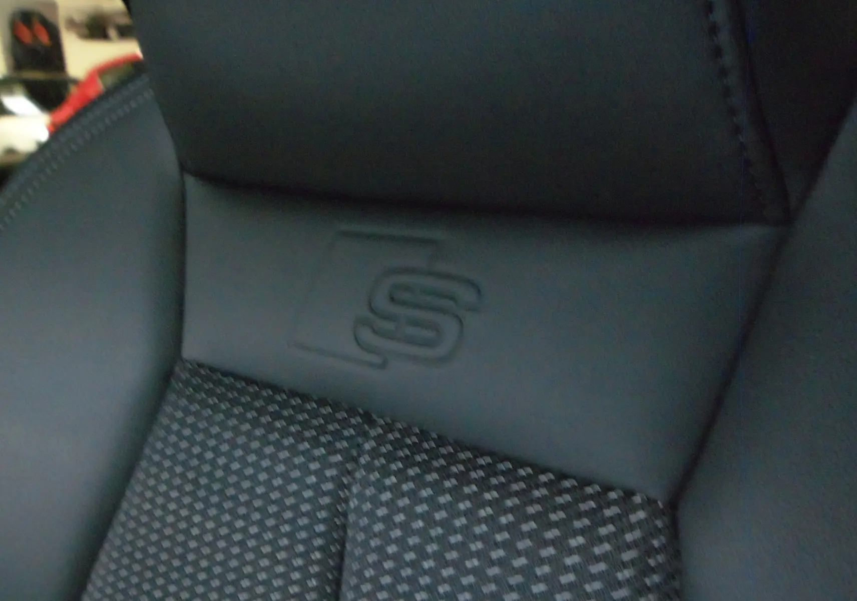 Détail du siège avant en cuir noir avec logo S embossé, intérieur de l'Audi A3 Sportback 35 TFSI 2025.