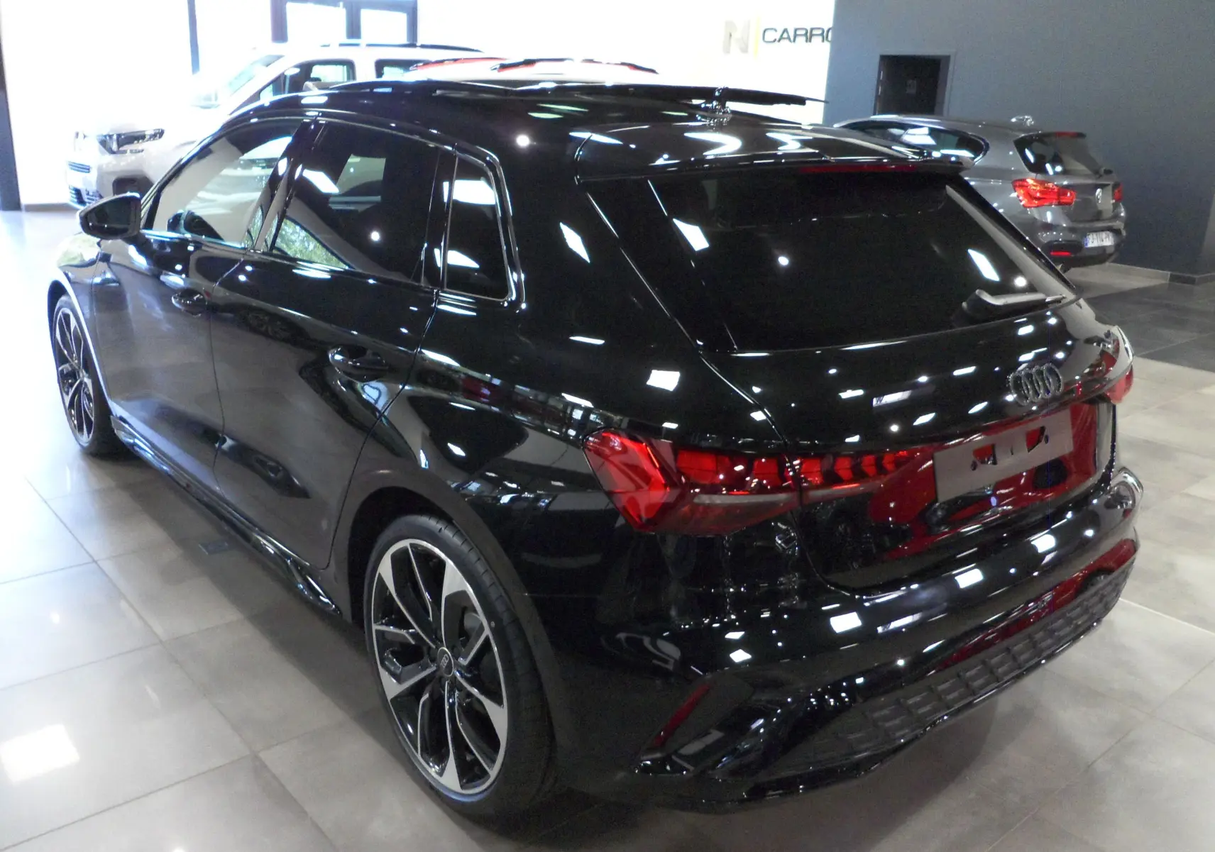 Audi A3 Sportback 35 TFSI S-Line noir mythe vue 3/4 arrière droit en intérieur avec jantes bi-ton distinctives