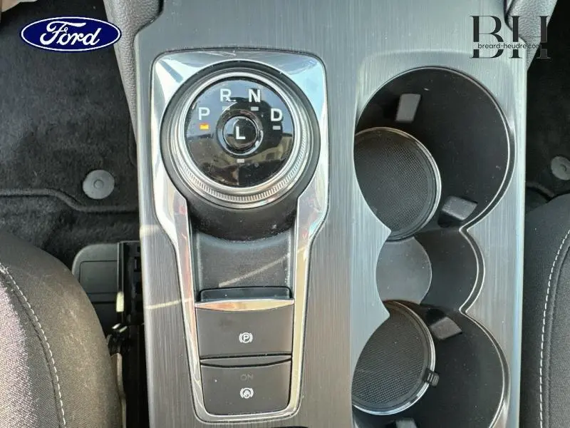 Vue rapprochée de la molette de sélection de vitesse et porte-gobelets du Ford Kuga gris Solar Métallisée 2023 Titanium.