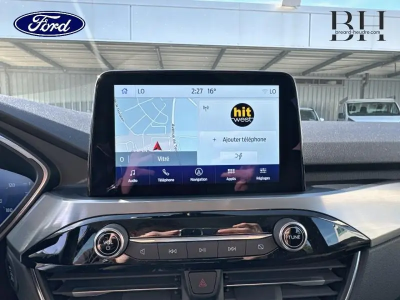 Écran tactile central avec navigation et commandes audio dans le tableau de bord du Ford Kuga gris Solar 2023.
