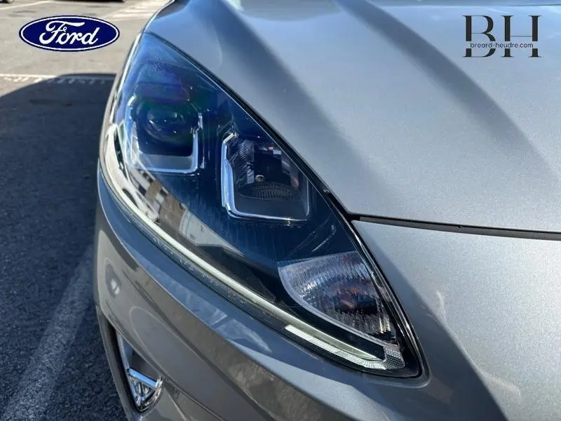 Gros plan sur le phare avant gauche du Ford Kuga gris Solar Métallisée 2023, soulignant ses détails modernes.