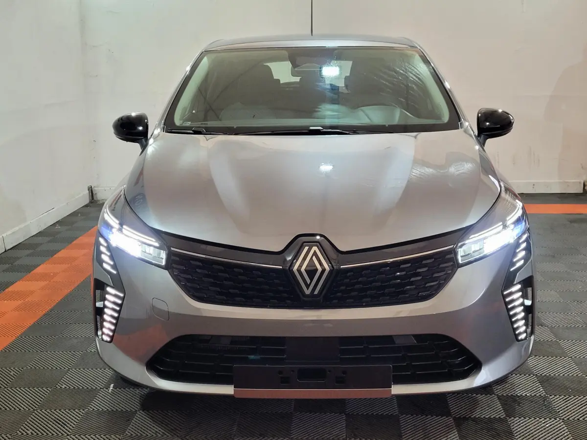 Renault Clio Evolution Blue dCi 100 2025 gris foncé vue de face avec phares LED allumés et calandre noire.