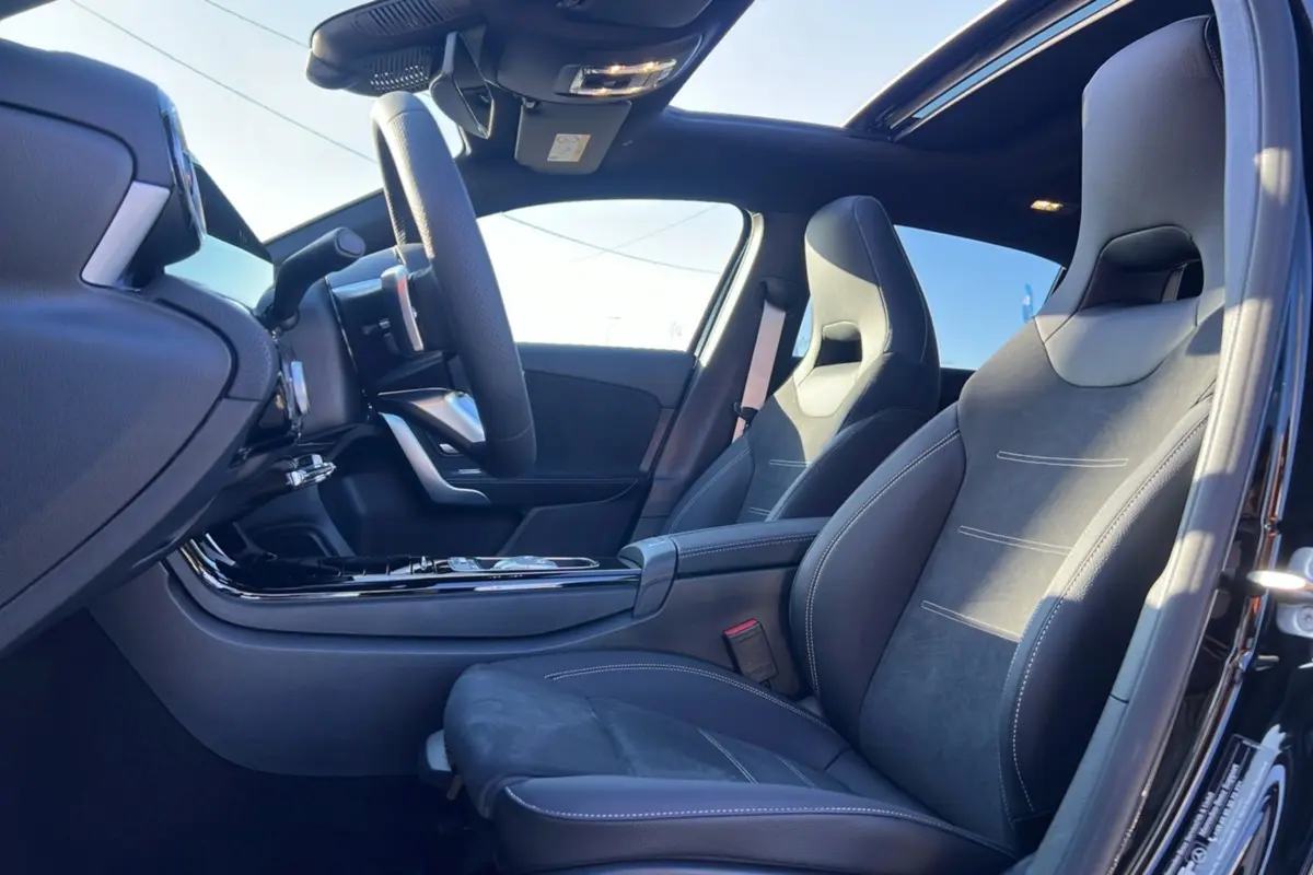 Vue intérieure côté conducteur de la Mercedes Classe A 200D Exclusive Design avec sièges sport cuir alcantara et toit panoramique.