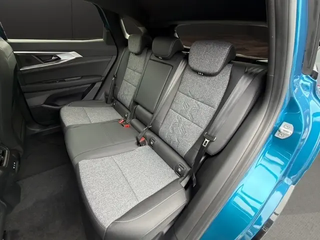 Vue intérieure côté droit sur la banquette arrière bi-matière grise et cuir du Renault Austral bleu 2026 avec porte ouverte.