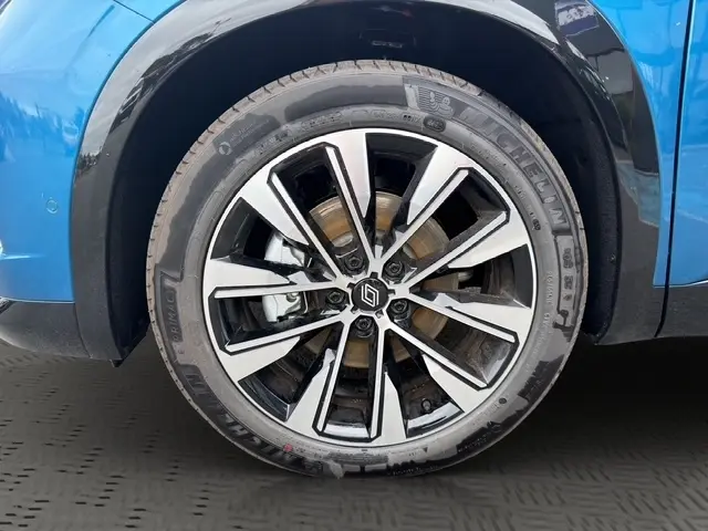 Gros plan sur la roue avant droite du Renault Austral bleu, mettant en valeur la jante alliage au design moderne.