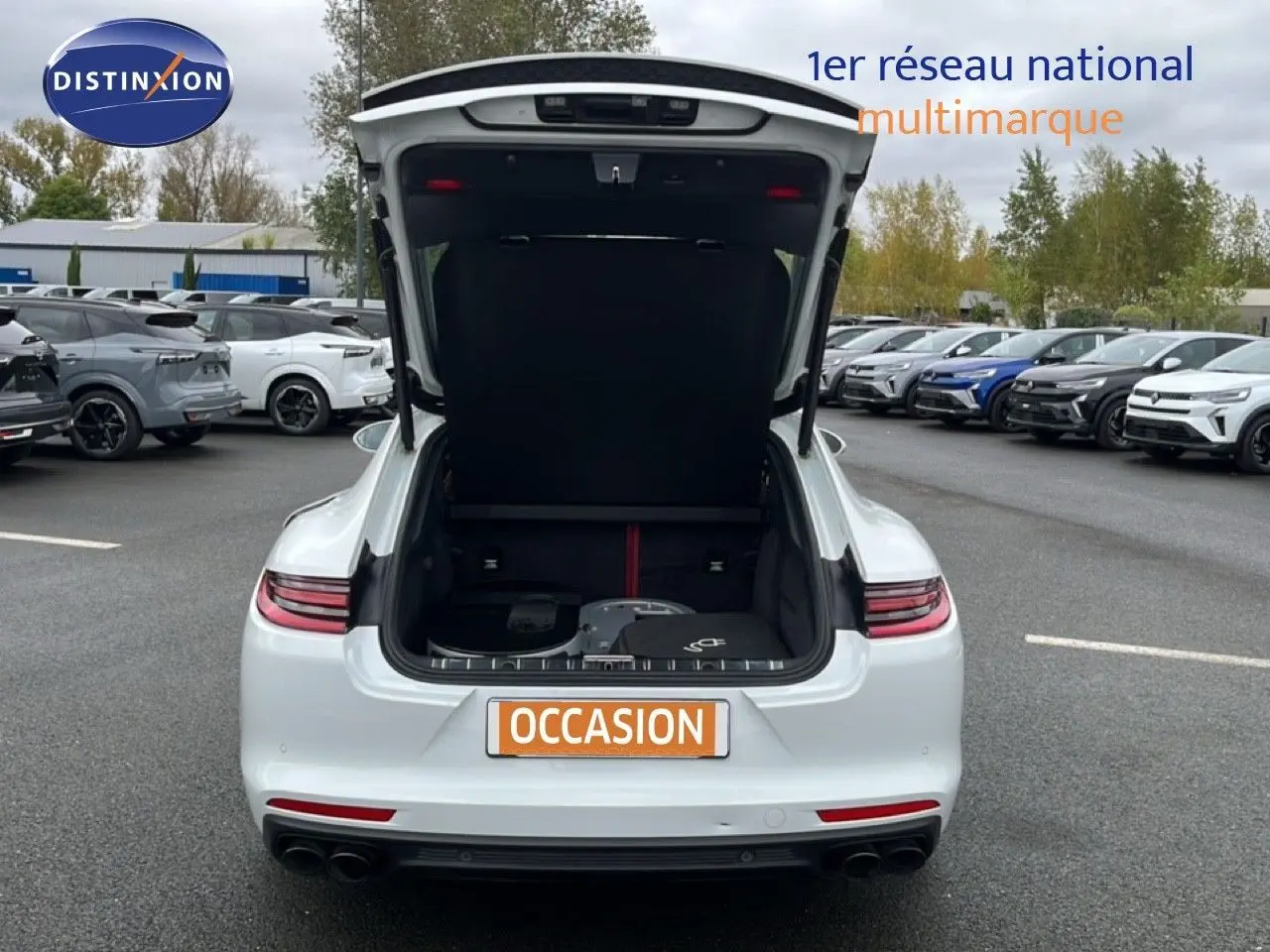 Vue arrière d'une Porsche Panamera 4 E-Hybrid blanche avec coffre ouvert montrant l'espace de chargement.